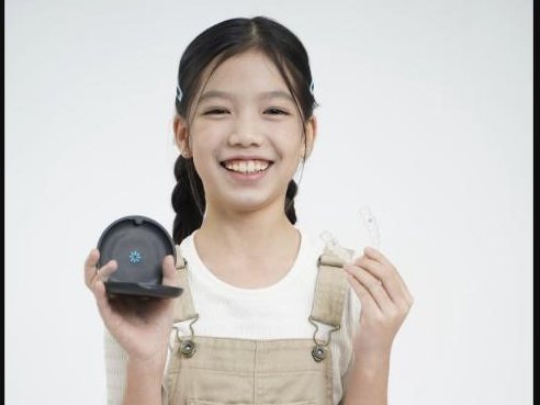 Young patient holding her retainer and its case